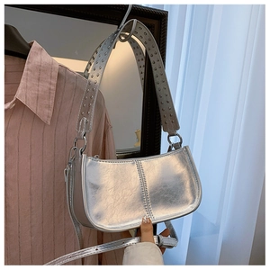 Détail du sac hobo argenté métallisé avec bandoulière à rivets et texture plissée