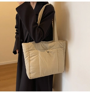 Detail view of the warm beige quilted tote bag showing soft fabric texture and snap closure