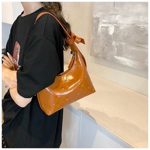 Détail du sac bandoulière en cuir PU caramel avec matelassage losange et rivets argentés