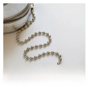 Detail view of silver pleated PU leather handbag with metallic beaded chain strap