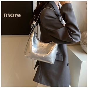 Détail du sac hobo argenté métallisé avec surpiqûres matelassées et rivets métalliques