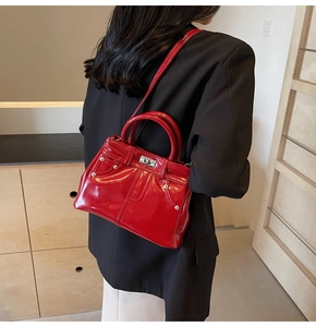 Détail du sac à main rouge brillant en PU avec fermoir rotatif et bandoulière élégante