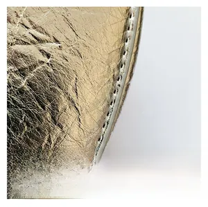 Detailed close-up of golden PU fabric with metallic texture and neat white stitching