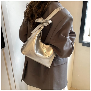 Détail du sac bandoulière argenté en PU métallisé avec matelassage et nœud clouté