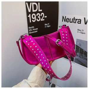 Détail du sac à bandoulière rose rouge métallisé avec rivets argentés et texture PU brillante