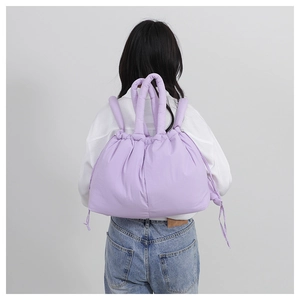Detail of light purple quilted nylon crossbody bag with drawstring and padded handles