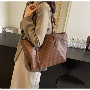 Detailed view of brown woven PU leather tote bag with long straps on model