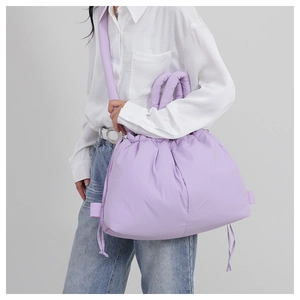 Detailed close-up of a puffy lavender nylon tote bag with drawstring closure and thick straps