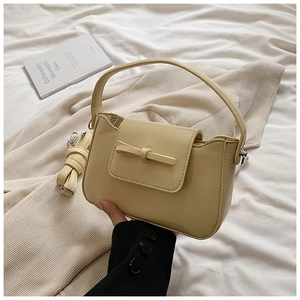 Elegant beige PU leather crossbody bag with decorative bow and detachable strap