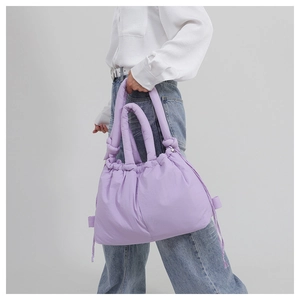 Detail of light purple puffy nylon handbag featuring drawstring closure and soft padded handle