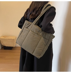 Olive green quilted tote bag shown on model, highlighting large capacity and soft texture