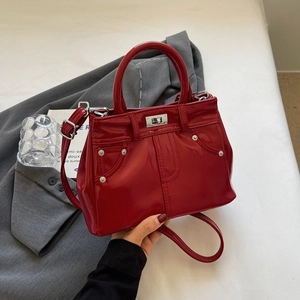 Sac à main en cuir verni rouge avec design poche en jean et fermoir rotatif métallique