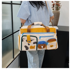 Detail der Nylon-Reisetasche mit Multi-Taschen, Color-Block-Design und 'hello weekend' Druck