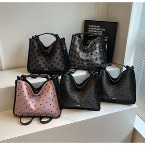 Collection of five stylish tote bags with metallic bow logos on tiered white displays