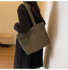 Close-up of olive green quilted tote bag with magnetic clasp and wide shoulder strap