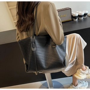 Macro detail of the high-quality woven PU leather texture on this black tote shoulder bag