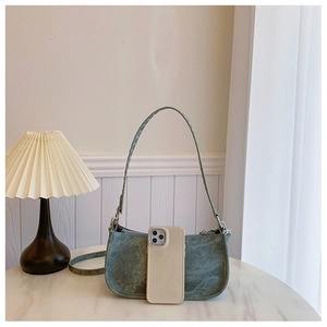 Détail du mini sac porté épaule vert gris mat avec finitions argentées et un smartphone