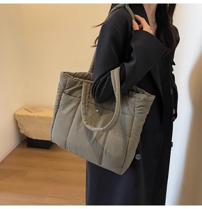 Detailed side view of Army green quilted puffer tote bag with wide padded handles and soft fabric