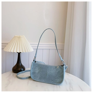 Détail du sac à bandoulière en PU bleu clair texturé avec garniture argentée