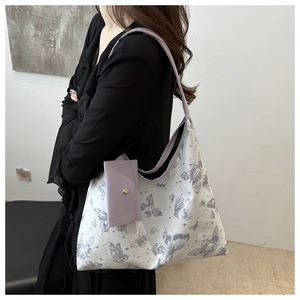 Détail du sac cabas en PU imprimé avec motifs papillon violets et large bandoulière