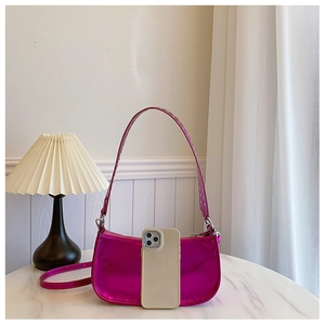 Détail du sac fuchsia métallisé avec rivets argentés et smartphone pour référence de taille