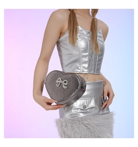 Detail view of heart-shaped silver PU bag with pleated texture and sequined bow decoration