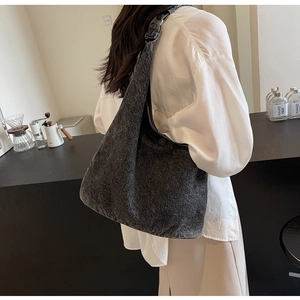 Detail of dark grey washed denim tote bag with textured fabric in a modern cafe setting
