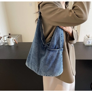 Detail shot of blue denim tote bag with stone washed texture and side pocket