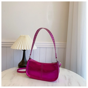 Détail du sac baguette en PU rose métallisé avec des clous argentés sur la bandoulière