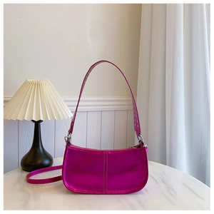 Détail du sac en cuir métallisé fuchsia avec bandoulière à rivets argentés et fermeture éclair