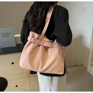 Detailed view of pale pink canvas tote bag with metal buckle and adjustable strap