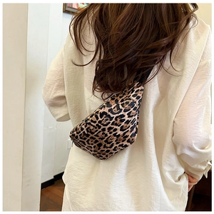 Detail shot of a stylish leopard print crossbody waist bag worn by a female model