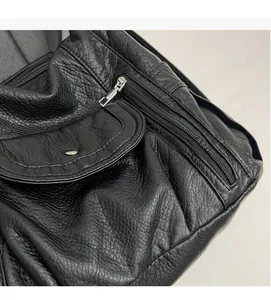 Close-up of black PU leather texture with metal zipper and snap button flap pocket