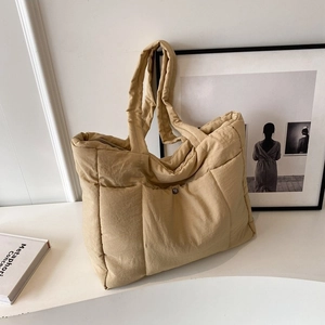 Minimalist beige quilted tote bag with large square stitching and zip closure for women