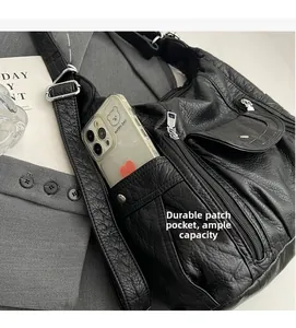 Detail of black pleated PU shoulder bag showing side pocket depth for smartphones