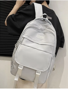 Détail d'un sac à dos en nylon gris clair avec logo FASHION porté par un mannequin femme