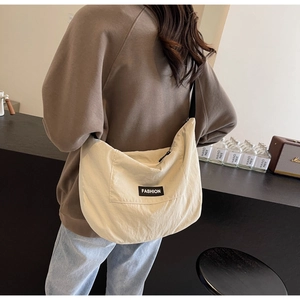 Chic beige nylon crescent crossbody bag with adjustable strap worn by a model