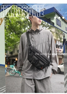 Close-up of black tactical nylon waist bag with multiple functional zipper pockets and wide strap