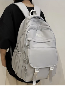 Vue détaillée du sac à dos en nylon imperméable montrant plusieurs poches et étiquette