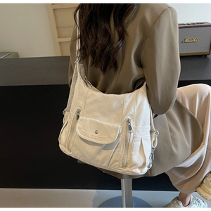 Close-up of hobo bag with multiple zipper pockets and silver metallic hardware detail