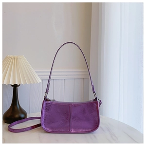 Détail du sac baguette en similicuir violet métallisé avec finitions à rivets punk