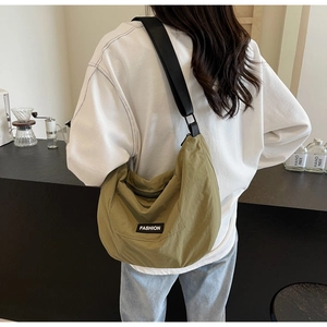 Detail of olive green nylon crescent crossbody bag with adjustable wide black strap