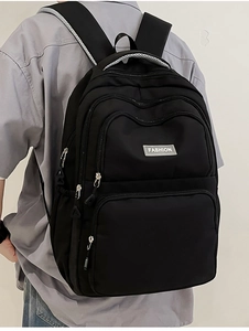 Detail of black nylon backpack featuring breathable mesh straps and FASHION label
