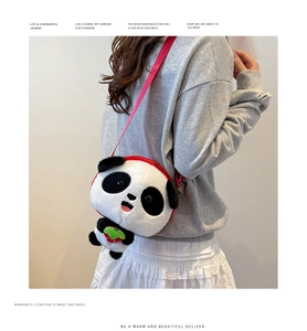 Close-up of plush panda crossbody bag with red strawberry detail and adjustable strap