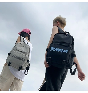 Detail view of large capacity nylon backpacks in grey and black against the sky background
