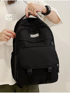 Détails du sac à dos en nylon noir montrant l'étiquette mode et les sangles à boucles