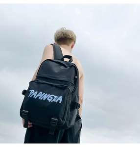 Detail of minimalist black nylon backpack with blue PAPINGJIA print and reinforced straps