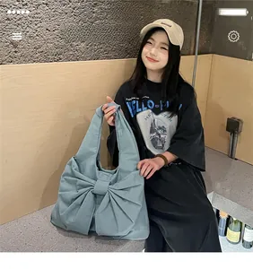 Détail d'un grand sac à main en denim en forme de nœud de couleur bleu morandi élégant