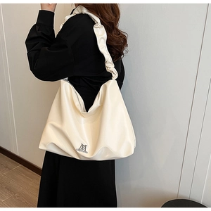 Detail of creamy white PU leather hobo bag with unique ruffled strap and metal logo