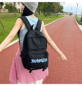 Detail view of black nylon backpack with multiple zipper pockets and large capacity storage